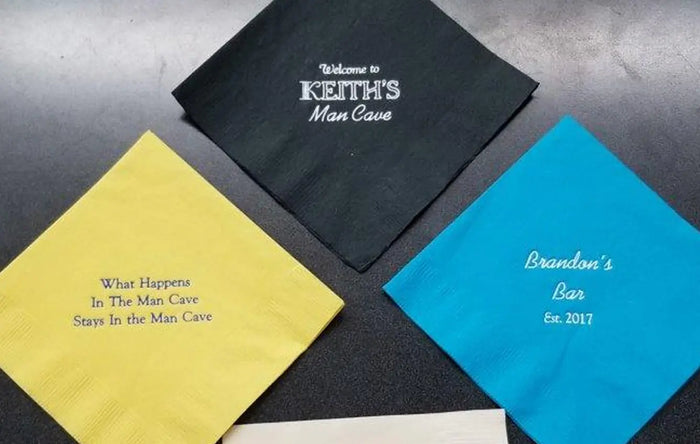 Personalized napkins with humorous sayings on a dark surface